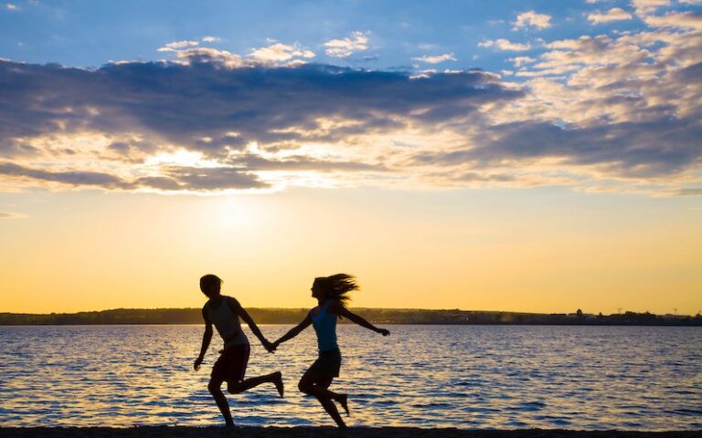 successful couple running on the beach